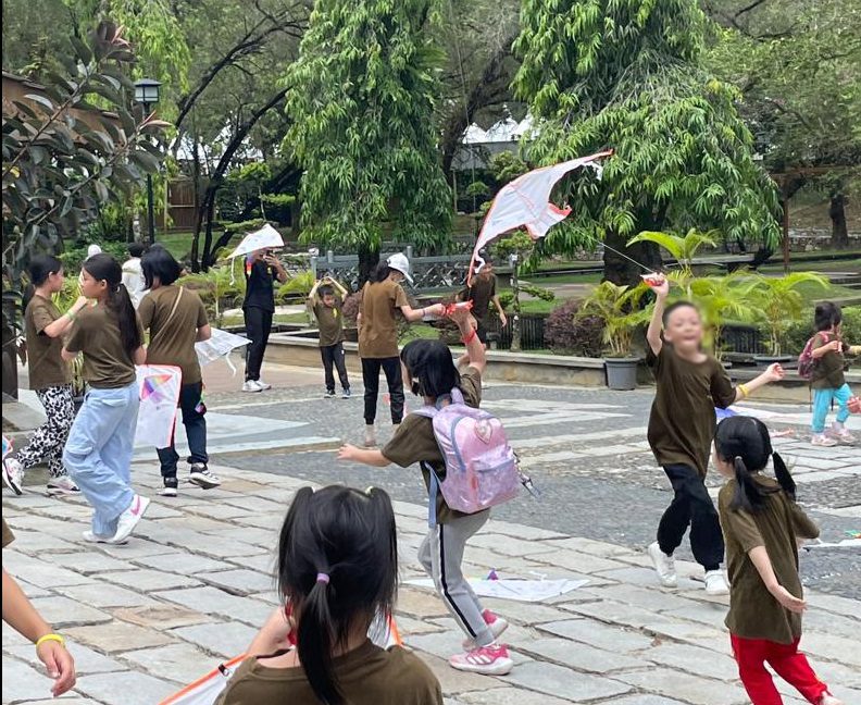 Students flying their painted kites outdoors