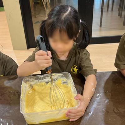 Child mixing batter in a baking session