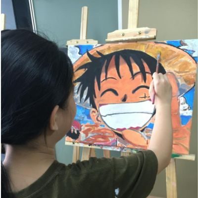 A student painting a cartoon character in acrylic