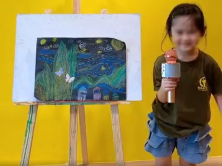 A young student presenting her painting
