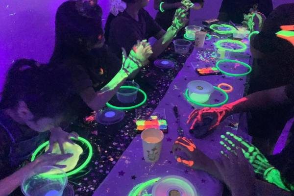 Children painting with glow-in-the-dark colours